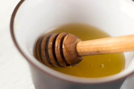 Honey spoon and fragrant honey in a bowl, macroの写真素材