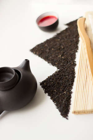 Oolong tea fresh red tea in a cup and black tea scattered in the shape of mountainsの写真素材
