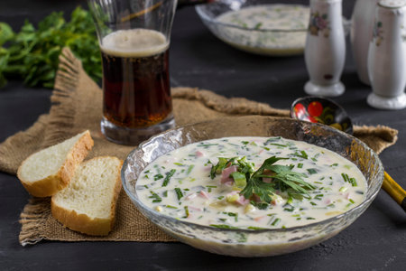 Cold Soup Okroshka. With sausage, vegetables and kvass serving size in bowl and raw ingredients on wooden tableの写真素材