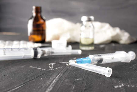 Medical ampoules with vaccine and syringe on gray background. Medical ampoules with pure vaccine and syringe on gray backgroundの写真素材