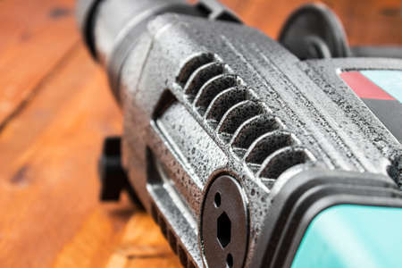 Industrial hammer drill. Perforator with a drill on a wooden background.の写真素材