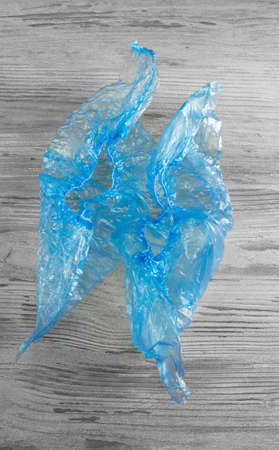 blue shoe covers on a wooden table top viewの写真素材