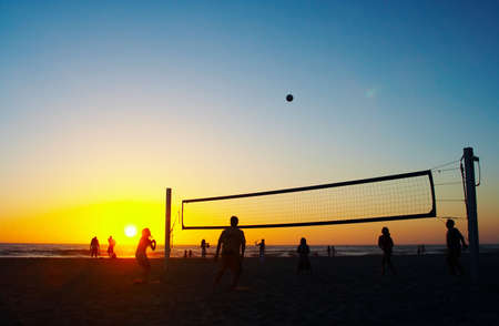 Family playing beach volleyballの写真素材