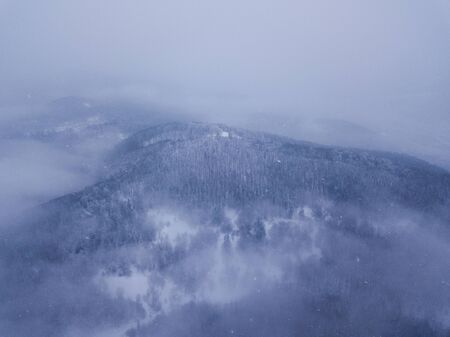  Beautiful view of the snow-capped peaks of the mountains that are covered with cloudsの写真素材