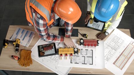 Young architects inspect new blueprints and equipmentの写真素材