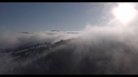  View of winter mountain snowy forest in the cloudsの写真素材
