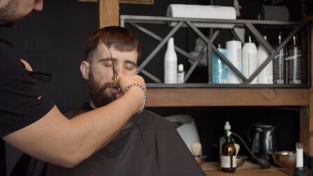 Young barber cutting hair of male clientの写真素材