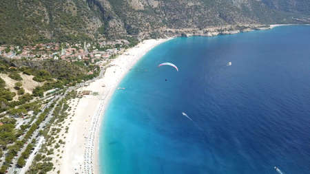 Paragliders flying over sea and beach on resortの写真素材