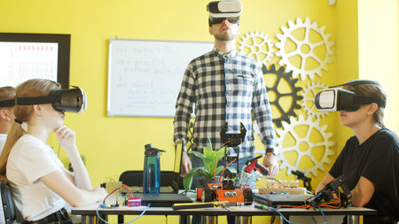 Young students and teacher with robot in classroom
