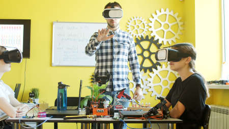 Young students and teacher with robot in classroomの写真素材