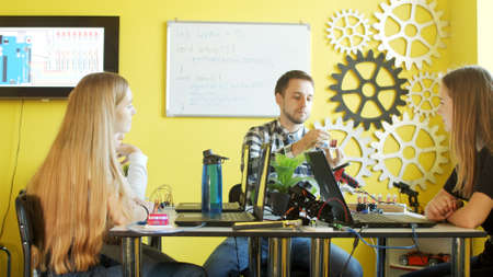 Group of students working together in classroom with laptopsの写真素材