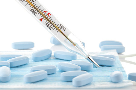 Medical Thermometer and medications on a medical mask. The most necessary for diseases, colds, flu,...