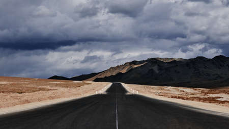 Road to the mountains. Paved road on the background of mountains. Road photography, Traveling by car.の写真素材