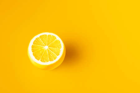 Bright yellow lemon on a yellow background.の写真素材