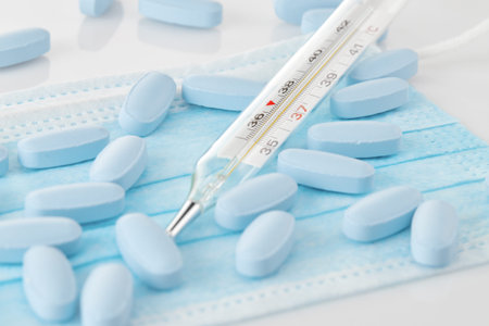 Medical Thermometer and medications on a medical mask. The most necessary for diseases, colds, flu,...