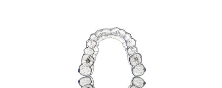 Invisible orthodontics cosmetic brackets on white background, tooth aligners, plastic braces. A way...