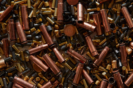 Different size bullet shells on the black ground. War concept. production of ammunition at the factory. brass bullet shell, ammunition manufacturing processの写真素材