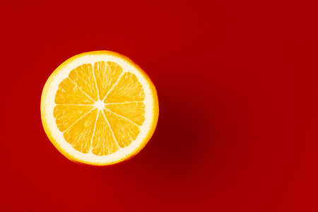 Bright yellow lemon on a red background.の写真素材