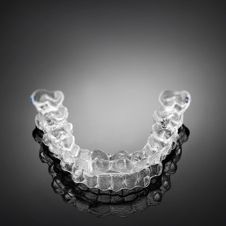 Invisible orthodontics cosmetic brackets on gradient background, tooth aligners, plastic braces....