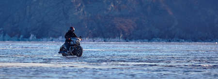 Biker riding on motorcycle Harley Davidson on a frozen lake. 08/03/2019 BAIKAL LAKE, OLKHON ISLAND, IRKUTSK REGION, RUSSIAのeditorial素材