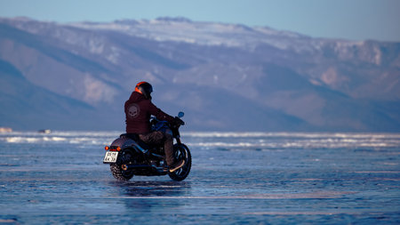 Biker riding on motorcycle Harley Davidson on a frozen lake. 08/03/2019 BAIKAL LAKE, OLKHON ISLAND, IRKUTSK REGION, RUSSIAのeditorial素材