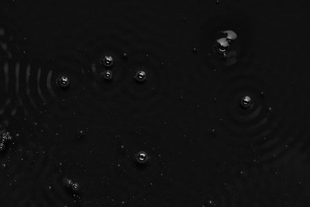 Bubbles on the surface of the liquid. Abstract Black Background Liquid Texture.