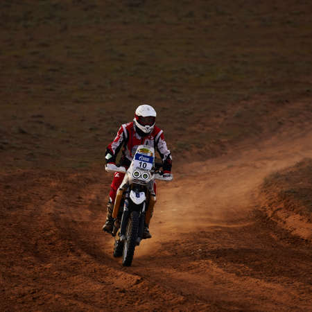 Rider on a off-road motorbike on the desert rally. Rally raid THE GOLD OF KAGAN-2021. 04.24.2021 Astrakhan, Russia.のeditorial素材