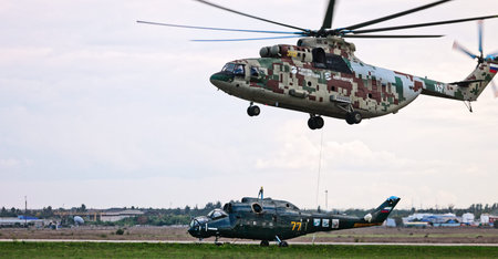 Transport helicopter Mi-26 T2B transports the fuselage of a combat helicopter on the external...