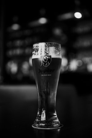 Glass of Belgian Jupiler beer. glass of beer on a table in a bar on blurred bokeh background. Saint Petersburg, Russia, 19.06.2021.のeditorial素材