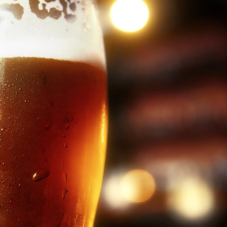 Glass of beer on a table in a bar on blurred bokeh backgroundの写真素材