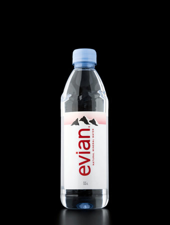Evian Natural Mineral Water on the black background. Evian is a brand of mineral water coming from...
