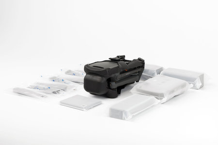 New DJI Mavic 3 drone on a white background when unpacking. Parts of the delivery set in the...
