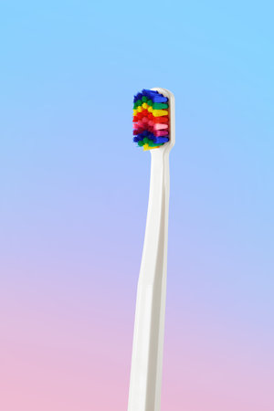 Fancy toothbrush with multicolored bristles. Bristles in all colors of the rainbow. Rainbow toothbrush with white knob. Fashionable oral care.の写真素材