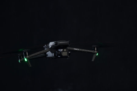 Flying a quadcopter at night, in the rain. DJI Mavic 3 - flying a copter in the rain. Closeup drone on dark. Most popular drone. Modern copter. 12.01.2022 Rostov-on-Don. Russiaのeditorial素材