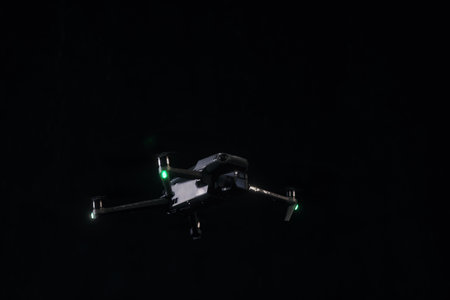 Flying a quadcopter at night, in the rain. DJI Mavic 3 - flying a copter in the rain. Closeup drone on dark. Most popular drone. Modern copter. 12.01.2022 Rostov-on-Don. Russiaのeditorial素材