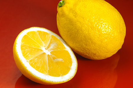 Lemon. A whole lemon and cut in half on a red background. Prevention of colds. Fluの写真素材