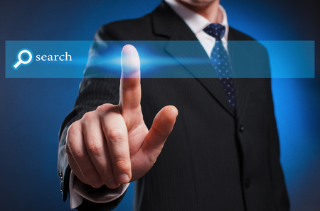 Virtual multimedia display. A man in a suit and tie clicks theの写真素材