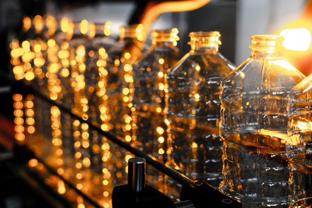 Bottle. Industrial production of plastic pet bottles. Factory line for manufacturing polyethylene bottles. Transparent food packaging.の写真素材