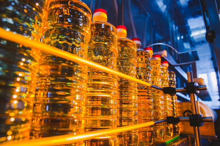 Sunflower oil. Factory line of production and filling of refined oil from sunflower seeds. Factory conveyor of food industry.の写真素材