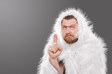Caveman in animal skin on isolated background shows thumb up.