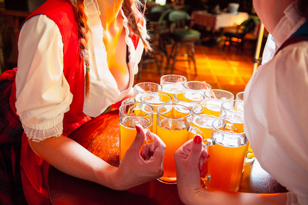 A lot of glasses of beer between the breasts of young girls on the holiday Oktoberfest.の写真素材