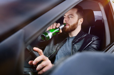 Drinks alcohol in the car. The guy with beer at the wheel. Man with beer. emergency situation....
