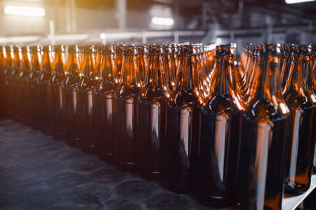 Rows of glass beer bottles of brown color close up on the stackの写真素材