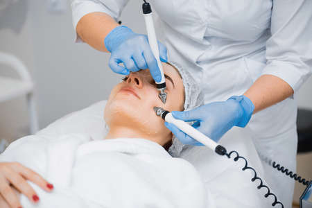 Doctor makes facial massage to a young girl using microcurrents.の写真素材
