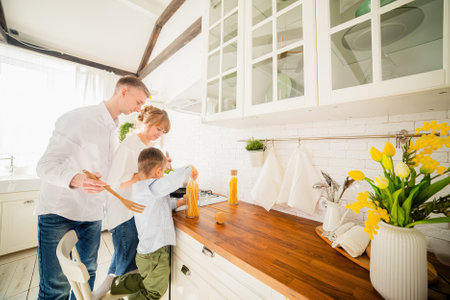 Happy family with little son cooking together in the kitchenの写真素材