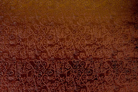 Texture of red satin fabric with floral embossing.の写真素材
