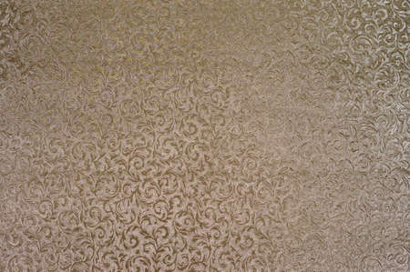 Texture of golden satin fabric with floral embossing.の写真素材