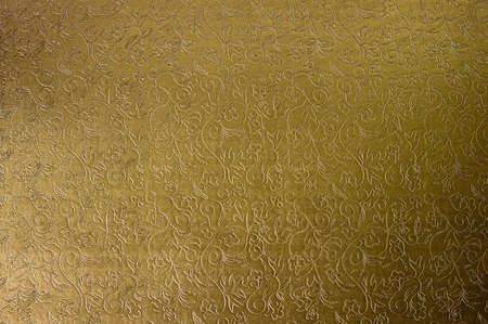 Texture of golden satin fabric with floral embossing.の写真素材