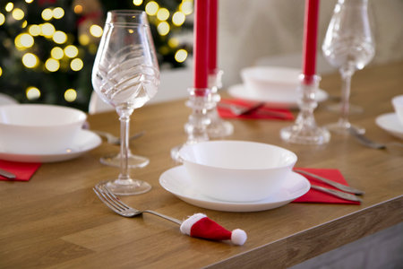 An example of a Christmas serving of a festive table. Cutlery decorated with Santa hat. Creative table decoration for the holiday.の写真素材