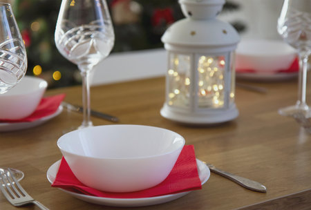 Top view of the Christmas setting of the festive table. Beautiful white kitchen appliances on the background of a bright flashlight. The concept of holidays with family and friendsの写真素材
